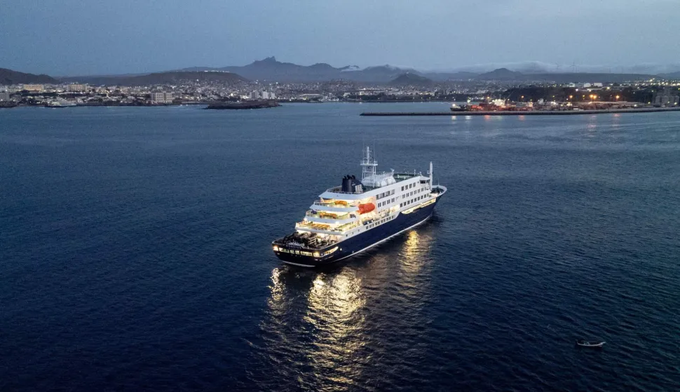 A general view of the cruise ship MV Hondius, while stationary off the port of Praia, the capital of Cape Verde, on May 6, 2026. Two seriously ill crew members on a cruise ship stricken by a deadly hantavirus outbreak will be evacuated via Cape Verde to the Netherlands, allowing the vessel to sail on to Spain's Canary Islands, the ship operator said on May 5, 2026.The MV Hondius has been at the centre of an international health scare since Saturday, when WHO was informed that the rare disease -- usually spread from infected rodents typically through urine, droppings and saliva -- was suspected of being behind the deaths of three of its passengers.As others fell ill, passengers and crew have been in isolation after Cape Verde authorities barred the ship from docking, and as health authorities scrambled to find a port that would take the Hondius. (Photo by AFP)