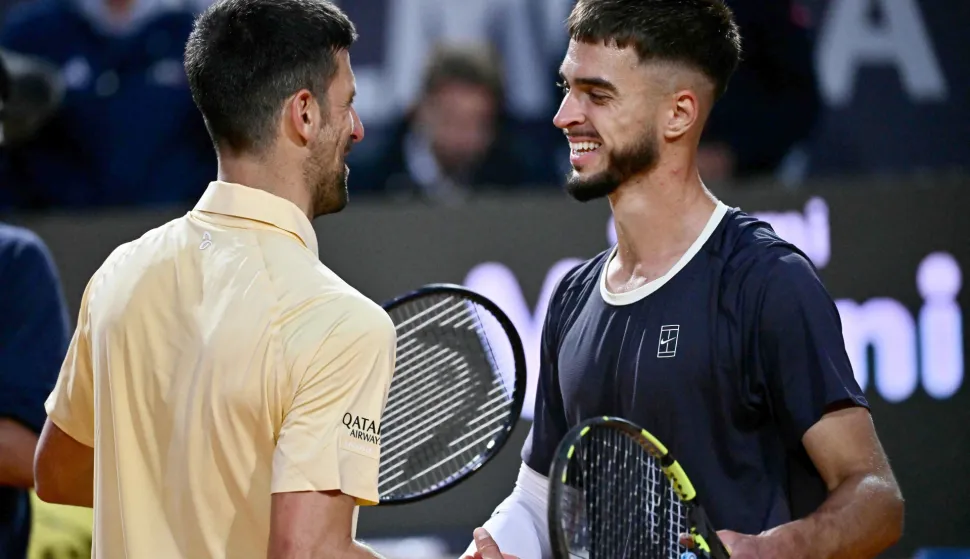 DINO PRIŽMIĆ, NOVAK ĐOKOVIĆ Croatia's Dino Prizmic (R) shakes hands with Serbia's Novak Djokovic after winning their men's singles match of the WTA Rome Open tennis tournament at the Foro Italico in Rome on May 8, 2026. (Photo by Filippo MONTEFORTE/AFP) 