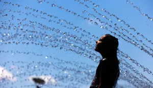 epaselect epa11455608 Caroline Gilligan cools off in a water fountain in the Georgetown Waterfront in Washington, DC, USA, 03 July 2024. The DC area is bracing for another heat wave, with temperatures for much of the coming week expected to be in the mid-90s Fahrenheit (35 degrees Celsius). EPA/JIM LO SCALZO