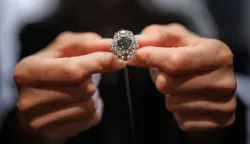 (FILES) A Christie?s member of staff shows a triangular-shaped fancy vivid blue-green diamond weighing 5.50 carats, known as "The Ocean Dream", during a press preview at Christie?s auction house in Geneva, on May 7, 2026. A vivid blue-green diamond of 5.50 carats, the largest known to date, was sold for more than  million on Wednesday in Geneva, exceeding expectations, Christie's announced. (Photo by Fabrice COFFRINI/AFP)