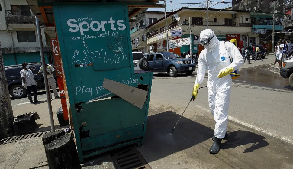 epa09012263 (FILE) - A Liberian health worker disinfects a street corner where a suspected Ebola patient was picked up and taken into an ambulance to be transported to an Ebola treatment unit in Monrovia, Liberia, 23 October 2014 (reissued on 14 February 2021). According to a statement from the office of Liberian President George Weah on 14 February 2021 the president has placed Liberia's health authorities on an increased alert level following the death of four people from Ebola in neighbouring Guinea marking five years since the last cases were recorded. EPA/AHMED JALLANZO