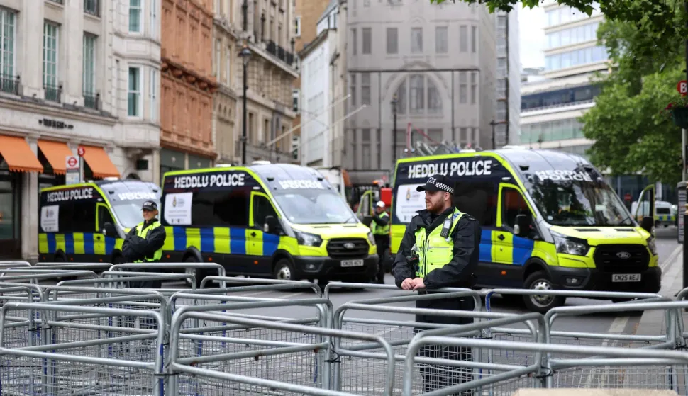 Police officers stand guard before supporters of British far-right activist Tommy Robinson, real name Stephen Yaxley-Lennon, take part in a march organised by Unite The Kingdom, in central London on May 16, 2026. (Photo by Toby Shepheard/AFP)