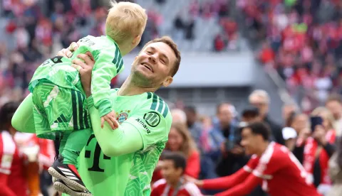 Bayern Munich's German goalkeeper #01 Manuel Neuer celebrates with his child after the German first division Bundesliga football match between FC Bayern Munich and FC Cologne in Munich, southern Germany, on May 16, 2026. (Photo by Alexandra BEIER/AFP)/DFL REGULATIONS PROHIBIT ANY USE OF PHOTOGRAPHS AS IMAGE SEQUENCES AND/OR QUASI-VIDEO