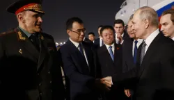 In this pool photograph distributed by the Russian state agency Sputnik, Russia's President Vladimir Putin is welcomed by Chinese Foreign Minister Wang Yi and other officials upon his arrival at Beijing Capital Airport in Beijing late on May 19, 2026. (Photo by Vladimir SMIRNOV/POOL/AFP)