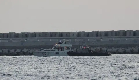 A boat bearing symbols of one of the vessels belonging to the Gaza-bound aid flotilla (L) and intercepted by the Israeli navy, is motored towards the Israeli port of Ashdod, about 40 kilometres south of Tel Aviv, on May 19, 2026. The Global Sumud Flotilla vessels are the latest in a string of attempts by activists to breach Israel's blockade of the Palestinian territory, with the last convoy intercepted by Israeli forces. Israel controls all entry points into Gaza, which has been under an Israeli blockade since 2007. During the Gaza war, triggered by Hamas's October 2023 attack on Israel, the territory has suffered severe shortages of food, medicine and other essential supplies, with Israel at times halting aid deliveries entirely. The Israeli ministry rejected claims that Gaza was facing aid shortages. (Photo by Jack GUEZ/AFP)