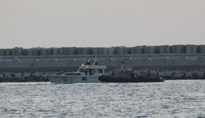 A boat bearing symbols of one of the vessels belonging to the Gaza-bound aid flotilla (L) and intercepted by the Israeli navy, is motored towards the Israeli port of Ashdod, about 40 kilometres south of Tel Aviv, on May 19, 2026. The Global Sumud Flotilla vessels are the latest in a string of attempts by activists to breach Israel's blockade of the Palestinian territory, with the last convoy intercepted by Israeli forces. Israel controls all entry points into Gaza, which has been under an Israeli blockade since 2007. During the Gaza war, triggered by Hamas's October 2023 attack on Israel, the territory has suffered severe shortages of food, medicine and other essential supplies, with Israel at times halting aid deliveries entirely. The Israeli ministry rejected claims that Gaza was facing aid shortages. (Photo by Jack GUEZ/AFP)