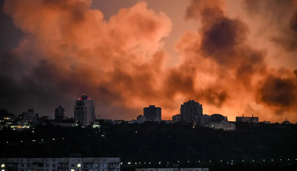 Smoke rises as the glow from fires light the sky during a Russian strike on the Ukrainian capital Kyiv on May 24, 2026, amid the Russian invasion in Ukraine. A large ballistic missile attack pounded Kyiv early on May 24, authorities said, wounding at least five people after Moscow threatened retaliation for strikes in Russian-occupied eastern Ukraine. (Photo by Evgen KOTENKO/AFP)