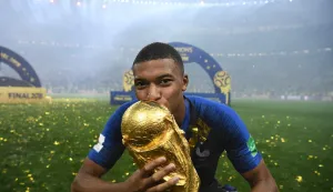 (FILES) France's forward Kylian Mbappe kisses the World Cup trophy after the Russia 2018 World Cup final football match between France and Croatia at the Luzhniki Stadium in Moscow on July 15, 2018. From the pioneers of the 1930 tournament to Lionel Messi's coronation in 2022, by the artistry of King Pele and the complex legacy of Diego Maradona, the Football World Cup is rich with great and small stories leading up to the 2026 edition in the United States, Canada, and Mexico. (Photo by FRANCK FIFE/AFP)/RESTRICTED TO EDITORIAL USE - NO MOBILE PUSH ALERTS/DOWNLOADS