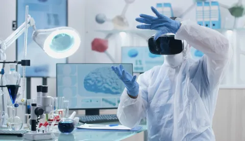 Scientist researcher wearing virtual reality headset analyzing brain activity futuristic holografic interface during chemistry experiment in biochemistry hospital laboratory. Neuroscience researchznanost medicina umjetna inteligencija