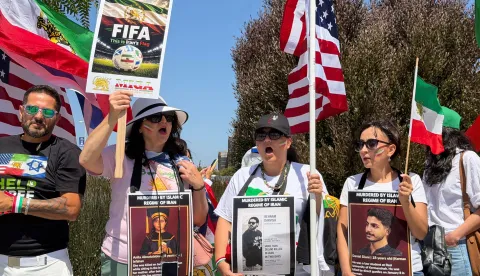 People wave US and pre-revolutionary Iranian flags as they protest the Iranian regime outside of Los Angeles Stadium (temporarly renamed from SoFi Stadium) in Inglewood, California, on June 7, 2026, ahead of the start of the 2026 FIFA World Cup. Iran are scheduled to open their Group G campaign against New Zealand in Los Angeles on June 15, before facing Belgium in the same city and then Egypt in Seattle. (Photo by Sarah LAI/AFP)