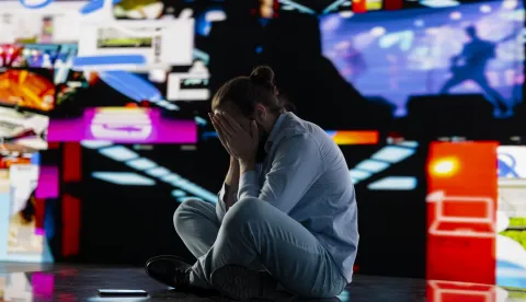 Paranoid guy suffers from emotional damage caused by obsessive social media use. Young man being overwhelmed by excessive information and comparison affecting his self esteem, manipulation.opasnost dru&scaron;tvene mreže nasilje depresija 