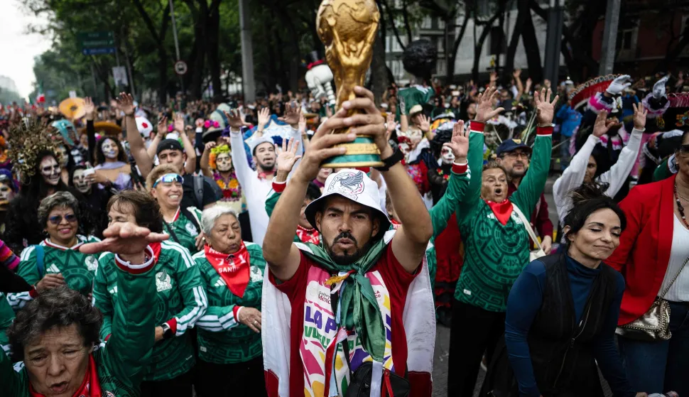 A man holds up a replica of a World Cup trophy before the start of a Guinness World Record attempt for the world?s largest Mexican Wave in Mexico City on June 6, 2026. (Photo by Carl de Souza/AFP)