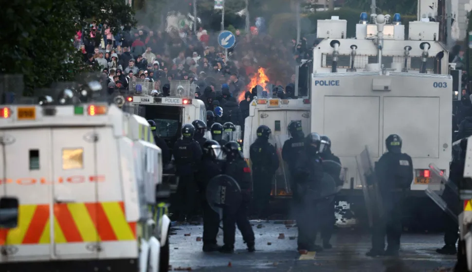 Police block the road from protesters (behind) leading to a hotel previously believed to house migrants, in Glengormley, north of Belfast, Northern Ireland, on June 10, 2026. Northern Ireland braced on June 10 for a potential second night of violence directed at immigrants, following unrest that UK authorities say was stoked by far-right activists on social media after a brutal Belfast stabbing. (Photo by Henry NICHOLLS/AFP)