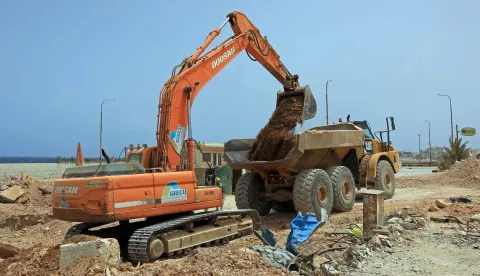 Labourers work at the construction site of a public service project being built as part of the reconstruction and urban expansion plan at the Al-Salam neighborhood in Derna on May 17, 2026. Nearly three years after a catastrophic storm tore through eastern Libya's port city of Derna killing almost 4,000 people the city is getting back on its feet, although the trauma persists. New roads and bridges, thousands of new homes, and a hospital have risen from the rubble since a storm swept the coastal city in 2023, leaving thousands missing and over 40,000 homeless. (Photo by Abdullah DOMA/AFP)