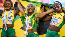 epa10077116 Gold medalist Shelly-Ann Fraser-Pryce of Jamaica (C), reacts after the women's 100 meter final next to Elaine Thompson-Herah of Jamaica (L), and Shericka Jackson of Jamaica (R), during the IAAF World Athletics Championships, at Hayward Field stadium, in Eugene, Oregon, USA, 17 July 2022. EPA/JEAN-CHRISTOPHE BOTT
