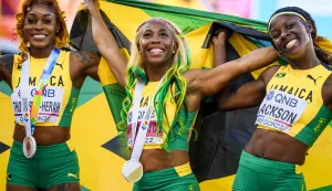 epa10077116 Gold medalist Shelly-Ann Fraser-Pryce of Jamaica (C), reacts after the women's 100 meter final next to Elaine Thompson-Herah of Jamaica (L), and Shericka Jackson of Jamaica (R), during the IAAF World Athletics Championships, at Hayward Field stadium, in Eugene, Oregon, USA, 17 July 2022. EPA/JEAN-CHRISTOPHE BOTT