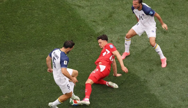 INGLEWOOD, CALIFORNIA - JUNE 18: Fabian Rieder #22 of Switzerland competes for the ball against Sead Kolasinac #5 and Ivan Sunjic #14 of Bosnia and Herzegovina during the FIFA World Cup 2026 Group B match between Switzerland and Bosnia and Herzegovina at Los Angeles Stadium on June 18, 2026 in Inglewood, California. Richard Heathcote/Getty Images/AFP (Photo by Richard HEATHCOTE/GETTY IMAGES NORTH AMERICA/Getty Images via AFP)
