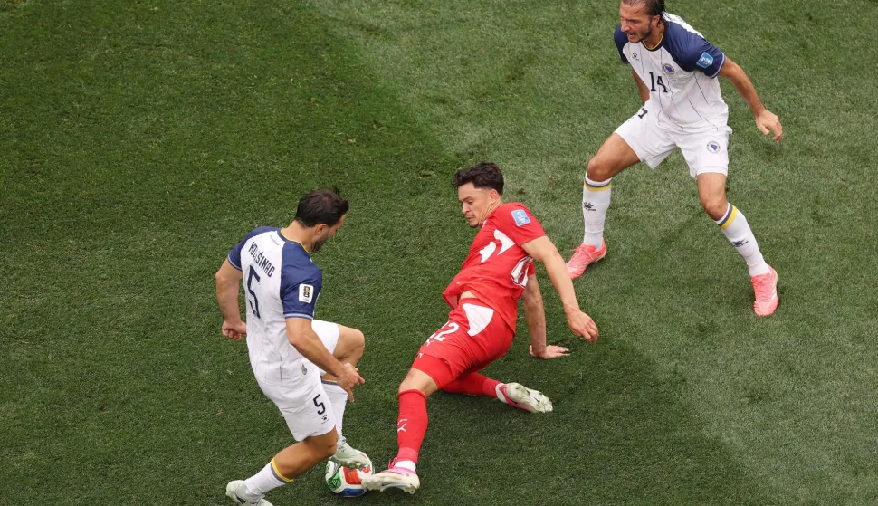 INGLEWOOD, CALIFORNIA - JUNE 18: Fabian Rieder #22 of Switzerland competes for the ball against Sead Kolasinac #5 and Ivan Sunjic #14 of Bosnia and Herzegovina during the FIFA World Cup 2026 Group B match between Switzerland and Bosnia and Herzegovina at Los Angeles Stadium on June 18, 2026 in Inglewood, California. Richard Heathcote/Getty Images/AFP (Photo by Richard HEATHCOTE/GETTY IMAGES NORTH AMERICA/Getty Images via AFP)