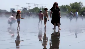 People cool off in a reflecting pool in Bordeaux, south-western France, on June 17, 2026. A heatwave will hit France on June 17, 2026 and last for several days, right in the middle of the baccalaureate exams, with temperatures that could reach up to 40?C in some areas on June 21, the first day of summer. (Photo by ROMAIN PERROCHEAU/AFP)