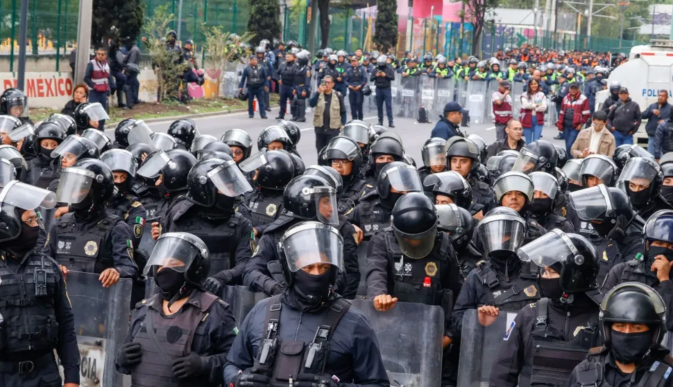 TOPSHOT - Members of the police block the way to the Ciudad de Mexico Stadium during a protest in Mexico City on June 9, 2026. Thousands of teachers blocked an avenue leading to the Azteca Stadium in Mexico City, 48 hours before the opening ceremony of the 2026 World Cup at that venue. (Photo by Gerardo Magallon/AFP)