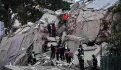 TOPSHOT - Rescuers search for victims in a collapsed building following an earthquake in Caracas on June 24, 2026. Two earthquakes of magnitude 7.2 and 7.5 struck the same area of Venezuela on the evening of June 24, causing buildings to collapse, according to the United States Geological Survey (USGS) and AFP journalists. The quakes drove residents of the capital, Caracas, into the streets. (Photo by Manaure Quintero/AFP)