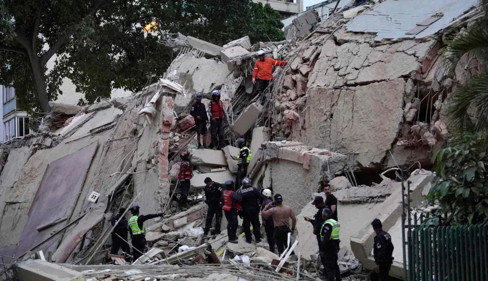 TOPSHOT - Rescuers search for victims in a collapsed building following an earthquake in Caracas on June 24, 2026. Two earthquakes of magnitude 7.2 and 7.5 struck the same area of Venezuela on the evening of June 24, causing buildings to collapse, according to the United States Geological Survey (USGS) and AFP journalists. The quakes drove residents of the capital, Caracas, into the streets. (Photo by Manaure Quintero/AFP)