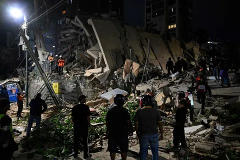 Rescuers search through the rubble of a collapsed building in the Altamira neighbourhood following an earthquake in Caracas on June 24, 2026. Two earthquakes of magnitude 7.2 and 7.5 struck the same area of Venezuela on the evening of June 24, causing buildings to collapse, according to the United States Geological Survey (USGS) and AFP journalists. The quakes drove residents of the capital, Caracas, into the streets. (Photo by Federico PARRA/AFP)