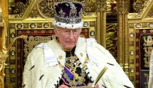 (FILES) Britain's King Charles III, wearing the Imperial State Crown and the Robe of State, sits on the the Sovereign's Throne as he makes his speech in the House of Lords chamber, during the State Opening of Parliament at the Houses of Parliament in London on May 13, 2026. Britain's King Charles III is expected to reveal his personal tax bill in a bid to improve transparency on June 25, 2026, as royal finances come under increasing public scrutiny in Britain. (Photo by Chris Jackson/POOL/AFP)