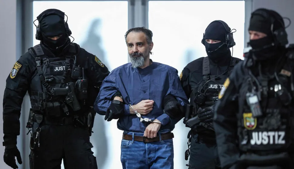Judicial officers escort Saudi Arabian defendant Taleb Al Abdulmohsen (2nd L) to the courtroom upon his arrival on June 26, 2026 in Magdeburg, eastern Germany, before his trial for driving an SUV through a crowd at a Christmas market. The court sentenced to life in jail the Saudi psychiatrist who drove an SUV through a crowded Christmas market in 2024, killing six people and injuring more than 300. (Photo by Ronny HARTMANN/AFP)