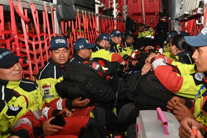 Ecuadorean firefighters of the Urban Search and Rescue (USAR) sit inside an Ecuador's Air Force Hercules plane early on June 26, 2026, at he Simon Bolivar air base in Guayaquil, Ecuador, before departing to Venezuela following deadly earthquakes. Desperate Venezuelans raced to find and rescue loved ones trapped alive beneath the rubble of collapsed buildings after two major earthquakes, measured at magnitudes 7.2 and 7.5, hit northern Venezuela killing at least 235 people and leaving more than 1,500 injured. (Photo by MARCOS PIN/AFP)