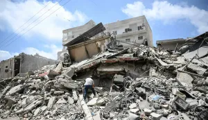 A man walks on the rubbles as he looks for items in a building hit in earlier Israeli military strikes on a neighbourhood in the southern Lebanese coastal city of Tyre on June 23, 2026. On June 22, 2026, mediators Pakistan and Qatar said that Tehran and Washington had agreed to set up a "de-confliction cell" to limit flare-ups in Lebanon following talks in Switzerland on ending the wider Middle East war, which Tehran has linked to halting the parallel conflict in Lebanon. (Photo by Joseph EID/AFP)/