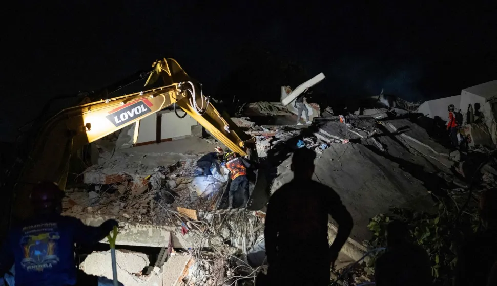 Members of Caracas firefighters work on the recovery of a dead body in a collapsed building in La Guaira, on June 27, 2026. The death toll from two powerful earthquakes that devastated Venezuela earlier this week rose to 920 on June 26, National Assembly President Jorge Rodriguez said. (Photo by Manaure QUINTERO/AFP)
