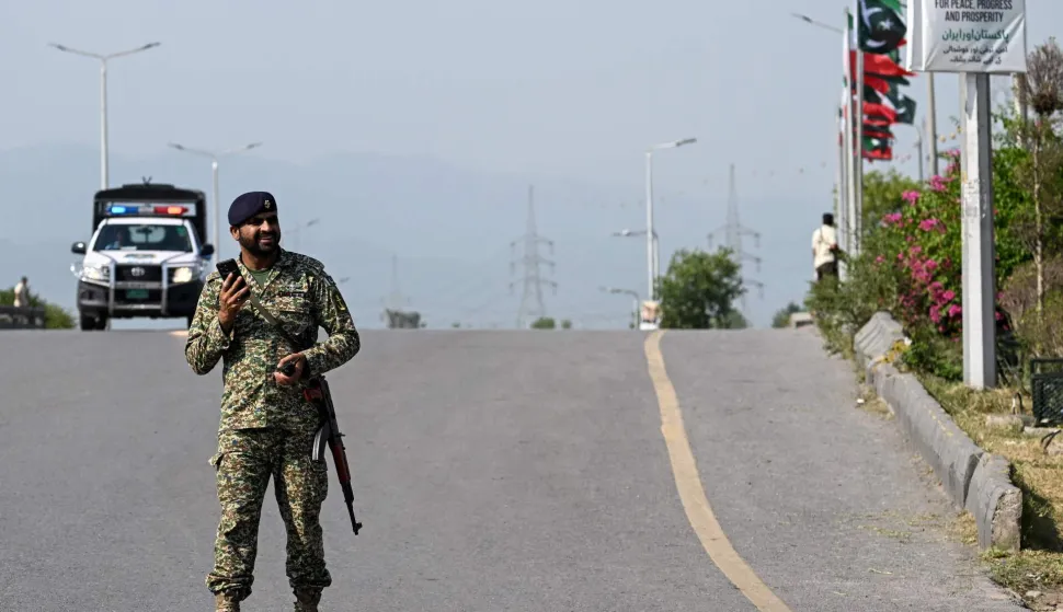 A security guard stands watch over a bridge as Iran's President Masoud Pezeshkian's motorcade makes its way upon his arrival in Islamabad on June 23, 2026 amid US-Iran peace talks. Iranian Foreign Minister Abbas Araghchi arrived in Islamabad on June 23, Iran's state media reported, as President Masoud Pezeshkian also travelled to Pakistan, which acts as a mediator in talks between Tehran and Washington. (Photo by Aamir QURESHI/AFP)