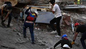 Volunteers work searching for possible victims at a collapsed building following twin earthquakes, in San Bernardino neighbourhood, in Caracas on June 27, 2026. The death toll in Venezuela's twin earthquake disaster reached 1,430 and millions more were feared to lack sanitation and other basic needs as the first US aid flights trickled into Caracas. (Photo by Juan BARRETO/AFP)