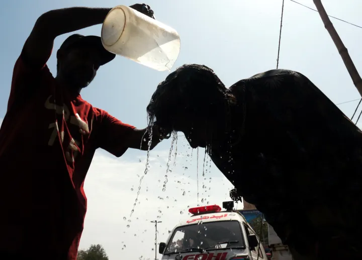 epa11488033 A man tries to cool off by getting water poured on his head at a roadside camp set up by the Edhi Foundation, as the heat wave continues in Karachi, Pakistan, 19 July 2024. The heatwave in Karachi has led to the hospitalization of 1,592 individuals at Jinnah Hospital within the past 24 hours, resulting in 49 fatalities, including 29 brought in dead, according to doctors. The city, currently experiencing extreme heat due to the suspension of sea breeze with temperatures soaring to a record 42 degree Celsius. Residents are advised to avoid sun exposure between 10am and 4pm. EPA/REHAN KHAN