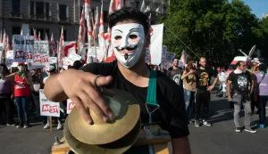 30 November 2018, Argentina, Buenos Aires: A demonstrator wearing an anonymus mask marches in front of Congress against the G20 summit taking place in Buenos Aires. On the summit days, 25,000 policemen and soldiers are deployed in the city. Photo: Carlos Brigo/dpa /DPA/PIXSELL