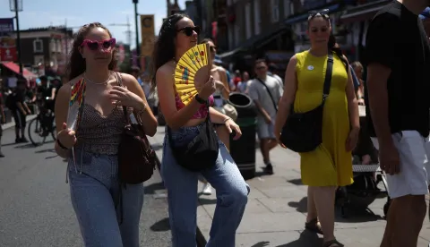 Shoppers use fans while visiting Camden in central London on June 27, 2026, during a heatwave. The UK broke the record for a June temperature for the third day in a row on Friday, the Met Office weather agency said, as a sweltering heatwave strained schools and hospitals and drove down business. A provisional 37.3 C record temperature was chalked up in Santon Downham, a village in Suffolk. (Photo by Toby Shepheard/AFP)
