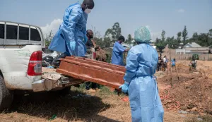 Teams from the International Federation of the Red Cross and Red Crescent Societies offload at Mbiyo cemetery the body of a fourth orphan who died from Ebola virus disease at an orphanage in Bunia, Ituri Province, June 19, 2026. A virus but no vaccine, a territory prey to armed groups and public distrust: Ebola resurfaced in mid-May at the borders of the DRC, Uganda and South Sudan. Since then, health authorities have been engaged in a race to catch up with the epidemic.On May 15, the Democratic Republic of Congo (DRC) declared the 17th Ebola outbreak, caused by the Bundibugyo strain, in the vast Central African country. The day before, tests carried out in a laboratory in the capital, Kinshasa, had confirmed the presence of the virus.The epicenter of the crisis is in Ituri, a troubled province in northeastern Congo marked by high population mobility linked to mining activity. Already 246 suspected cases, including 80 deaths, had been reported at that point. (Photo by Jospin Mwisha/AFP)