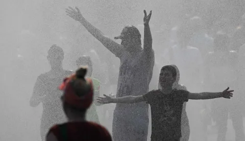 Police use water cannon to spray people with water as the arrive at the Olympic stadium for a concert of US singer Bruno Mars on June 28, 2026, in Berlin, as the German capital is expected to reach temperatures around 40 degrees Celsius during a heatwave in Europe. Tens of millions are braving a weekend of extreme temperatures in Europe as a deadly heatwave moves eastwards, with some countries announcing rising death tolls and health services warning of saturation. While some mild relief is expected Sunday in western Europe, German forecasters are warning that more temperature records could still be broken over the weekend as eastern countries issue a slew of red alerts for the coming days. (Photo by RALF HIRSCHBERGER/AFP)