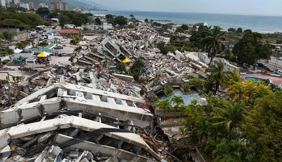 This aerial view taken on July 2, 2026 in Caraballeda in the state of La Guaira shows collapsed buildings following the June 24 twin earthquakes. More than a week after the earthquakes struck, there is little chance of finding additional survivors from the two earthquakes that killed nearly 2,300 people, destroyed entire residential buildings, and left tens of thousands missing. (Photo by Miguel MEDINA/POOL/AFP)