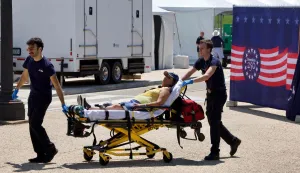 A person is helped by first responders as people cope with extreme heat along the National Mall in Washington, DC, on July 3, 2026, as high temperatures grip the US capital ahead of Independence Day celebrations. Blistering temperatures and humidity has gripped swaths of the United States this week, with more to come for the densely populated East Coast as the nation co-hosts the World Cup and prepares to celebrate its 250th birthday on July 4. The heat wave that has been broiling the Midwest is intensifying in the Northeast, with temperatures surpassing 100F (38C) in cities including New York, Philadelphia and Washington. (Photo by Amid FARAHI/AFP)