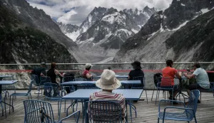 TOPSHOT - Tourists look at the Mont-Blanc massif mountains and the "Mer de Glace" glacier at the Montenvers station in the French Alps, central-eastern France on June 17, 2026. (Photo by Jeff PACHOUD/AFP)