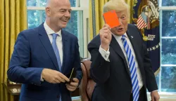 epa06979412 US President Donald J. Trump (R) holds up a FIFA red card that has his name on it, toward members of the news media, given to him by President of FIFA Gianni Infantino (L) during their meeting in the Oval Office of the White House in Washington, DC, USA, 28 August 2018. Along with the Canada and Mexico, the US will host the 2026 FIFA World Cup. EPA/MICHAEL REYNOLDS