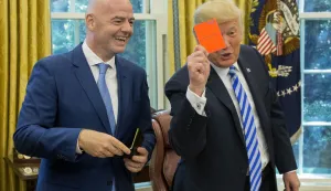 epa06979412 US President Donald J. Trump (R) holds up a FIFA red card that has his name on it, toward members of the news media, given to him by President of FIFA Gianni Infantino (L) during their meeting in the Oval Office of the White House in Washington, DC, USA, 28 August 2018. Along with the Canada and Mexico, the US will host the 2026 FIFA World Cup. EPA/MICHAEL REYNOLDS