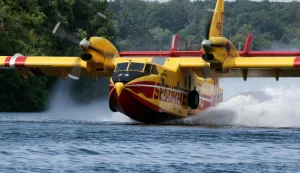 A Canadair CL-415 of the French civil security performs watter-scooping maneuvers by skimming across the Seine river in Chartrettes, in the Paris' Ile-de-France region on July 13, 2026, following the forest fire in Fontainebleau Forest. The fire that broke out on July 12 and swept through 800 hectares of the Fontainebleau forest, southeast of Paris, "could" have been "deliberately started," France's Interior Minister stated at the scene on July 13, 2026. (Photo by Thomas SAMSON/AFP)