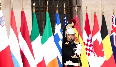 A French Republican Guard stands next to the flags during a summit of the Coalition of the Willing to support Ukraine at the Hotel des Invalides in Paris on July 13, 2026. The summit meeting of the Coalition of the Willing -- launched by France and the United Kingdom to provide military support to Ukraine after Russia's full-scale invasion -- will push for a ceasefire and renewed peace talks, the French presidency said. (Photo by Teresa Suarez/POOL/AFP)