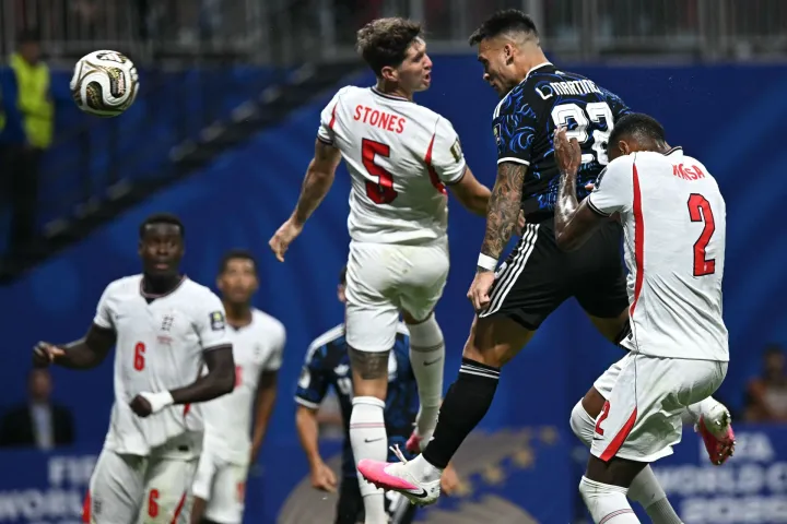 Argentina's forward #22 Lautaro Martinez (C) scores his team's second goal past England's defender #05 John Stones (L) and England's defender #02 Ezri Konsa during the 2026 World Cup football tournament semi-final match between England and Argentina at the Atlanta Stadium in Atlanta on July 15, 2026. (Photo by Paul ELLIS/AFP)