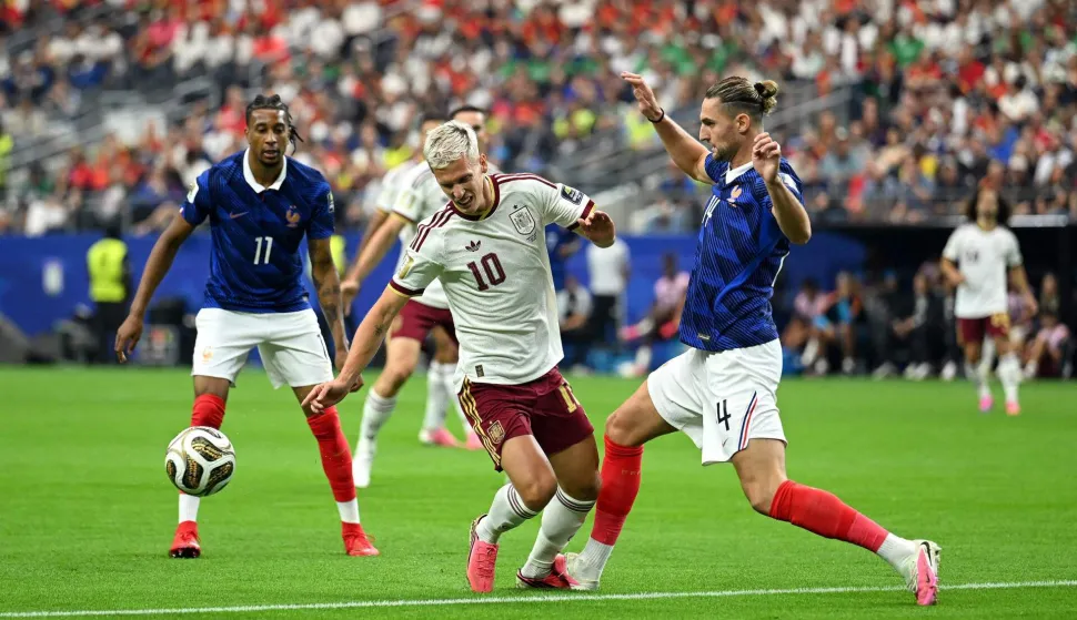 ARLINGTON, TEXAS - JULY 14: Dani Olmo #10 of Spain is fouled by Adrien Rabiot #14 of France during the FIFA World Cup 2026 Semi Final match between France and Spain at Dallas Stadium on July 14, 2026 in Arlington, Texas. Shaun Botterill/Getty Images/AFP (Photo by Shaun Botterill/GETTY IMAGES NORTH AMERICA/Getty Images via AFP)