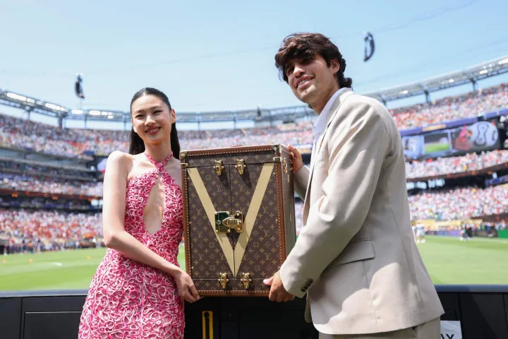 EAST RUTHERFORD, NEW JERSEY - JULY 19: Carlos Alcaraz and Hoyeon present the Louis Vuitton trophy trunk containing the FIFA World Cup Winner?s Trophy before the FIFA World Cup 2026 Final match between Spain and Argentina at New York New Jersey Stadium on July 19, 2026 in East Rutherford, New Jersey. Dan Mullan/Getty Images/AFP (Photo by Dan Mullan/GETTY IMAGES NORTH AMERICA/Getty Images via AFP)