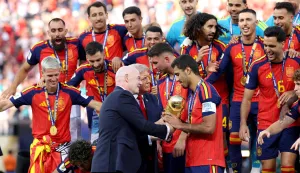 EAST RUTHERFORD, NEW JERSEY - JULY 19: Rodri #16 of Spain is presented the FIFA World Cup Winner?s Trophy by U.S. President Donald Trump and FIFA President Gianni Infantino after the team?s victory following during the FIFA World Cup 2026 Final match between Spain and Argentina at New York New Jersey Stadium on July 19, 2026 in East Rutherford, New Jersey. Carl Recine/Getty Images/AFP (Photo by Carl Recine/GETTY IMAGES NORTH AMERICA/Getty Images via AFP)